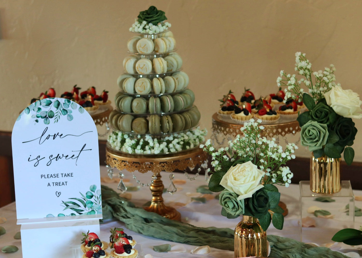 wedding dessert table with macarons and floral arrangements