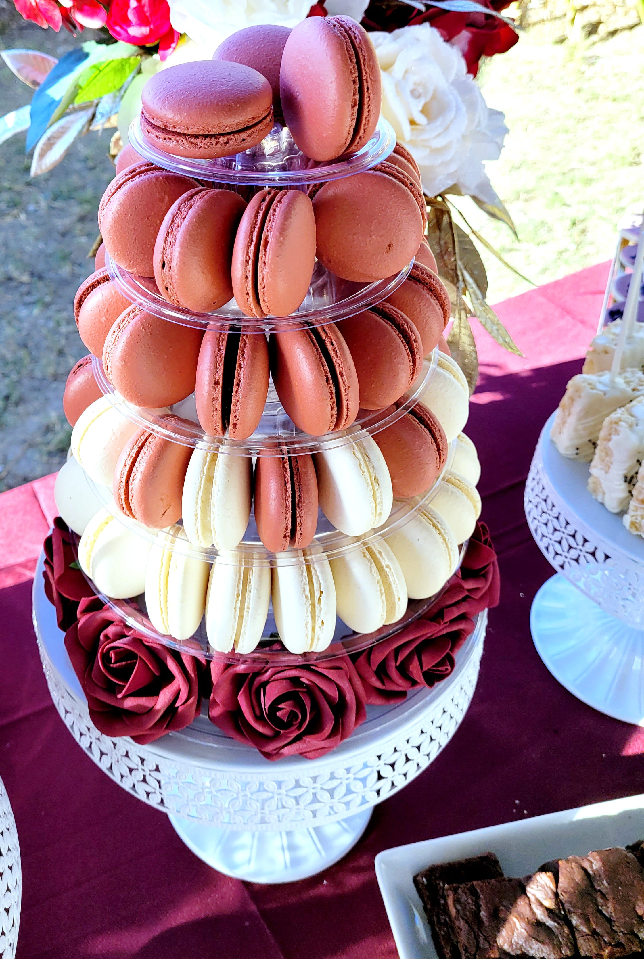 A close up picture of a macaron tower on a backyard wedding dessert table.