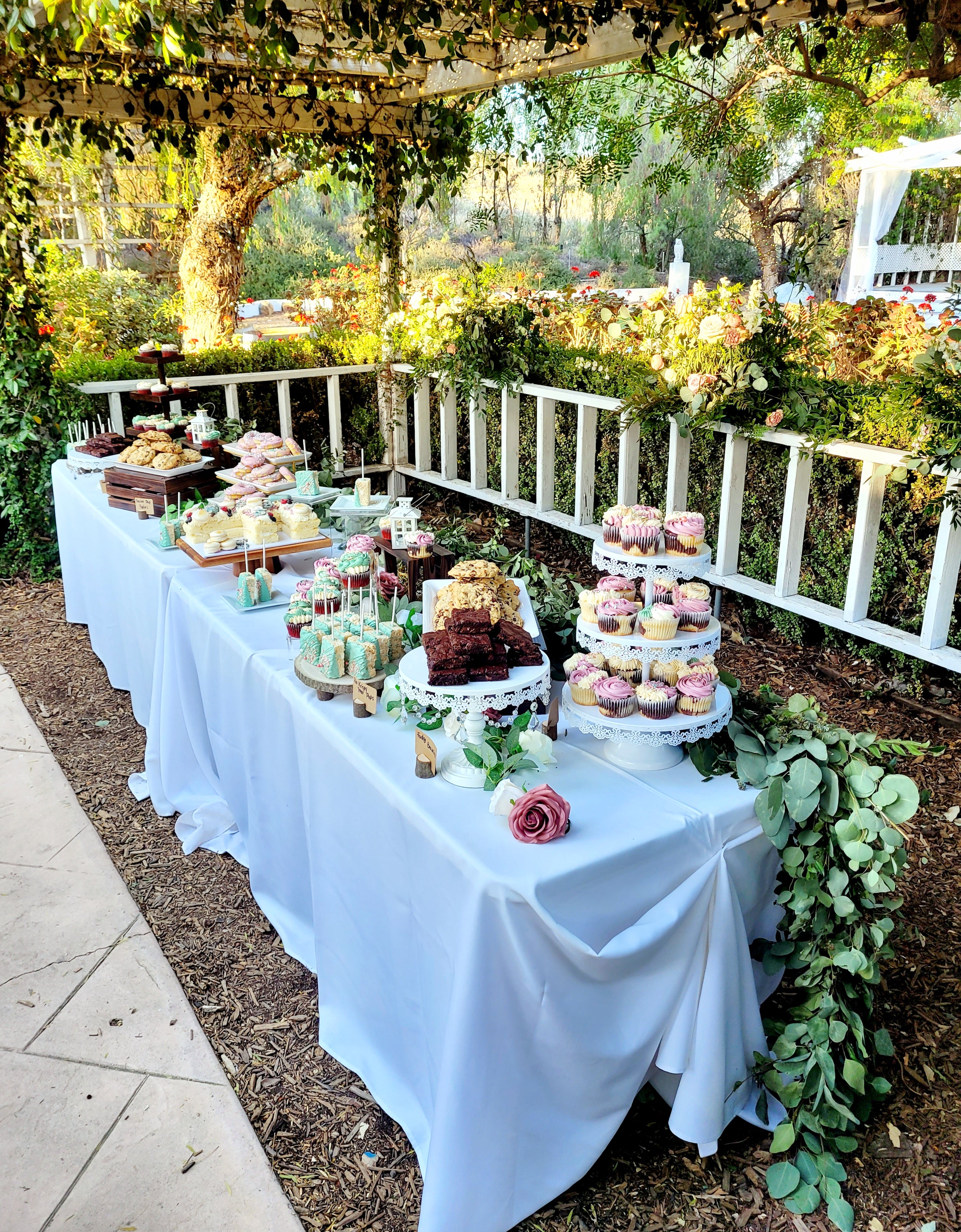 An outdoor wedding dessert table. Rustic with wooden accents.