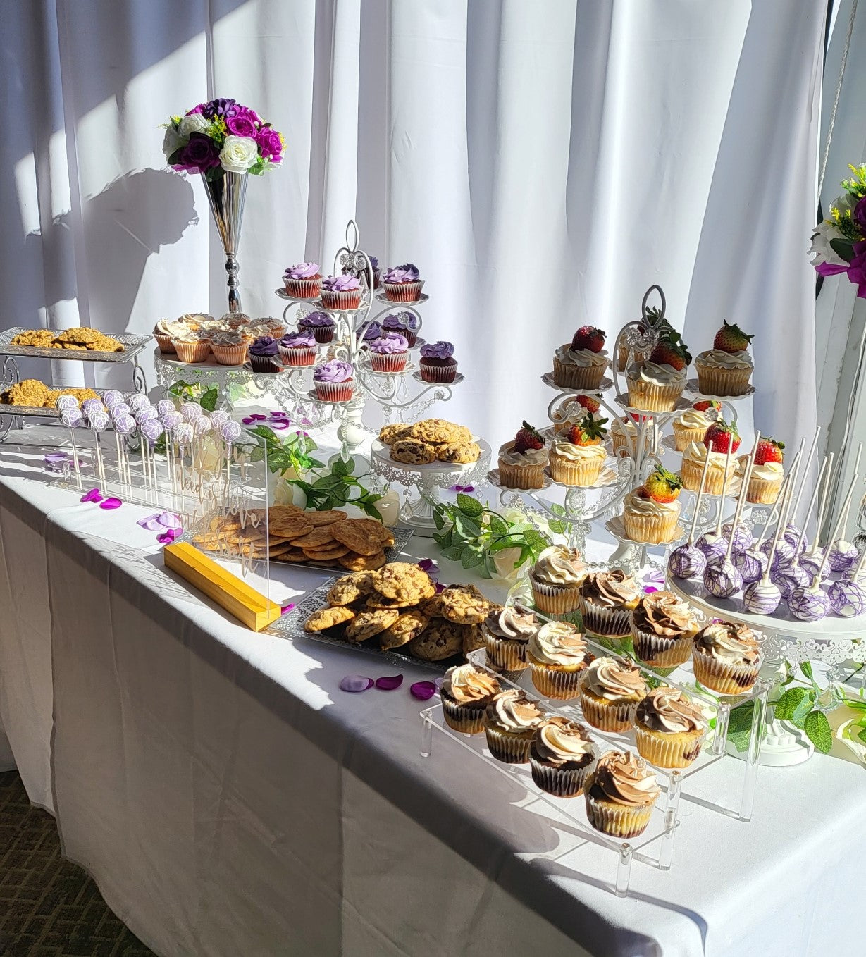 Purple and silver themed wedding dessert table with cupcakes, cookies and cake pops.